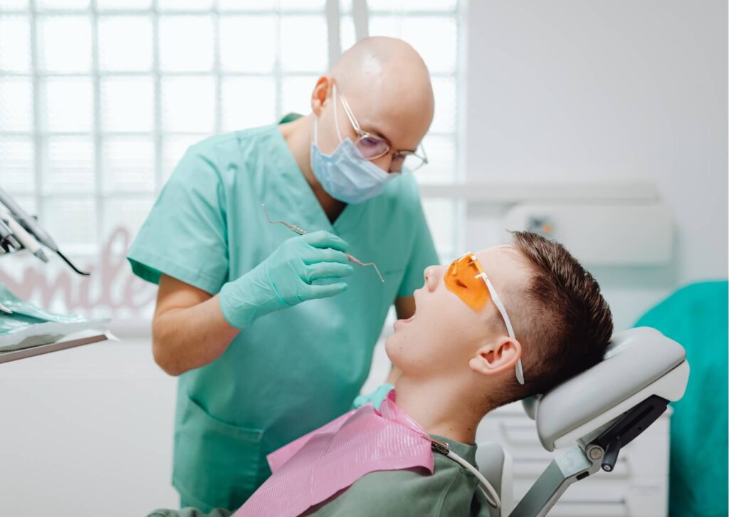 Dentist examining a patient's back teeth to evaluate whether an emerging wisdom tooth is growing in normally or causing crowding.